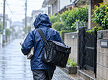 雨や悪天候の中での配布負担を表すイメージ