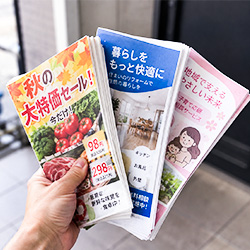 チラシを持って投函する手元