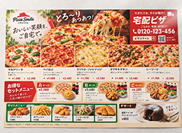 A3サイズの宅配ピザのメニューチラシ。横向きに完全に広げ、多くの商品を掲載した状態。